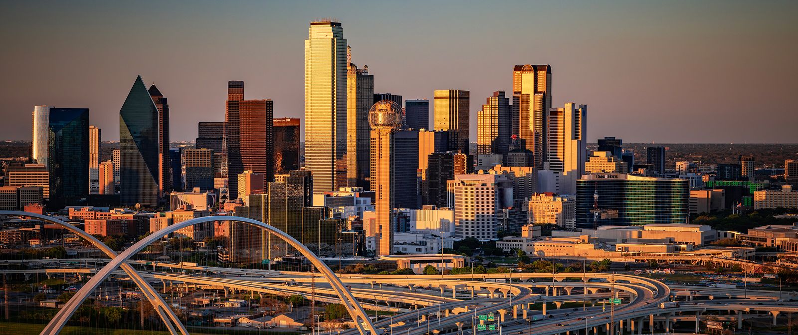 Dallas skyline at sunset with highways below.